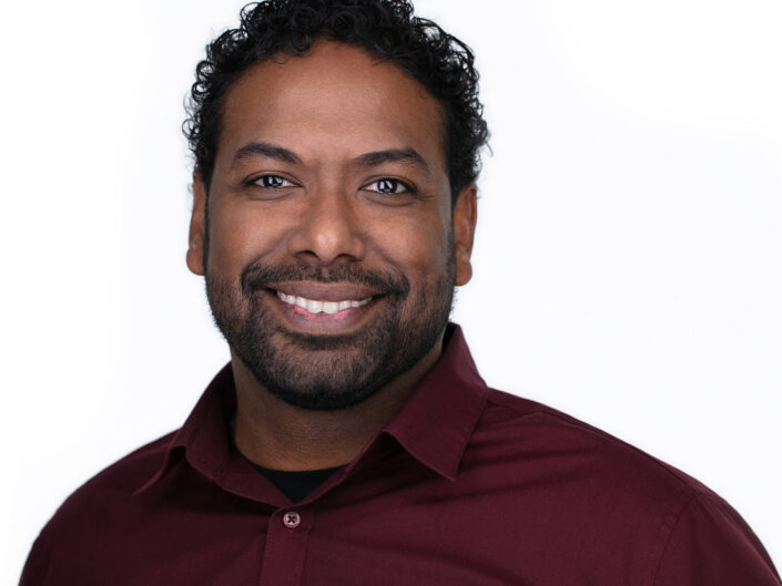 Employee headshot of man with curly hair